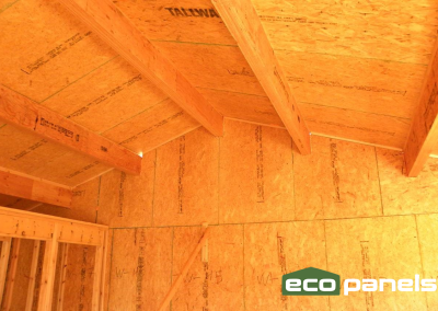 Interior photo showing roof panels, ridge beam and two purlins set into gable end.